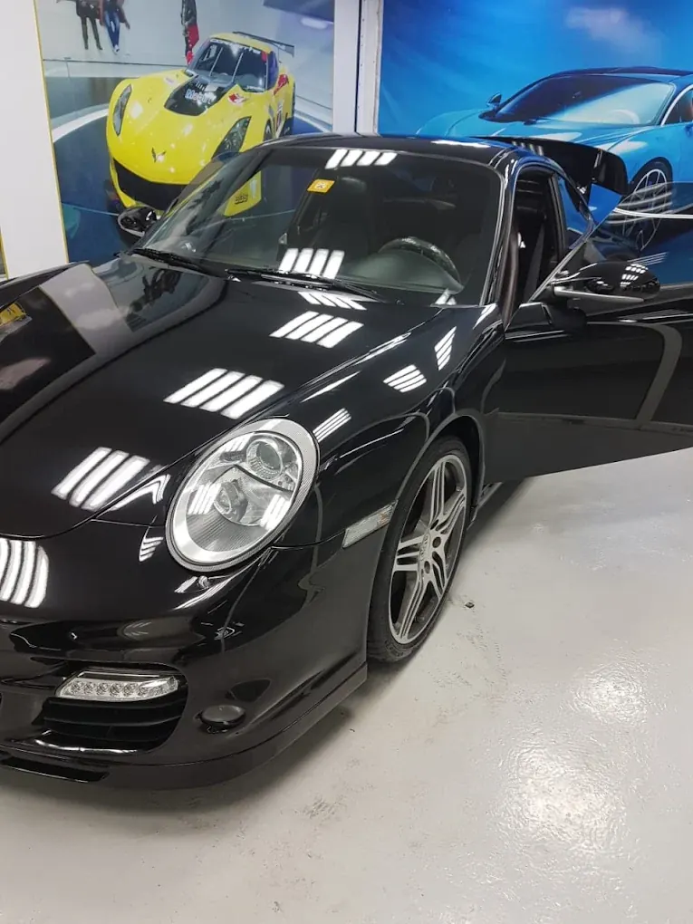 Black Porsche 911 prepared for detailing at Madeena Al Amwaj Auto Workshop